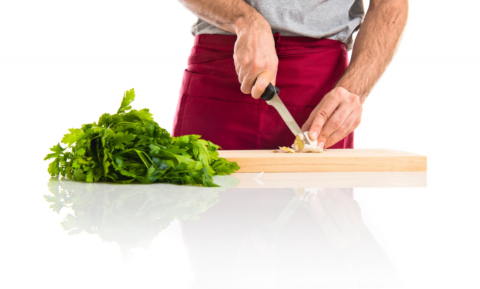 Chef che affetta verdure su banco di legno